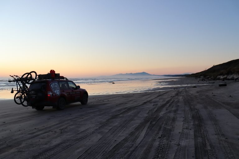 The Shredlys 4x4 pajero tour vehicle on a Tasmanian beach at sunset - MTB Tasmania