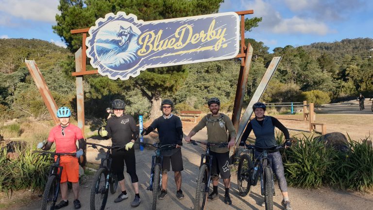 Blue Derby mountain bike trails guided group in front of the trail sign